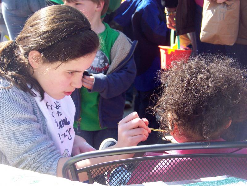 Face painting was on of many activities available for kids. Here Elise Mello, a Junior Friend of the Plumb Library, concentrates on her work. BY MATTHEW BERNAT